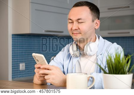 Happy Smiling Asiam Man Using Smartphone For Online Shopping Or Communication,answering Mail Etc.
