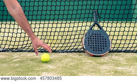 One Caucasian Man Catch A Yellow Ball Near The Padel Racket On Green Court Grass