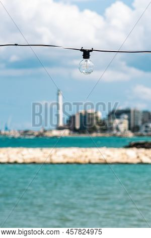 Vintage Light Bulbs With Blue Sky, White Clouds, Blue Sea And Breakwater, Bari Port Or Harbor With S