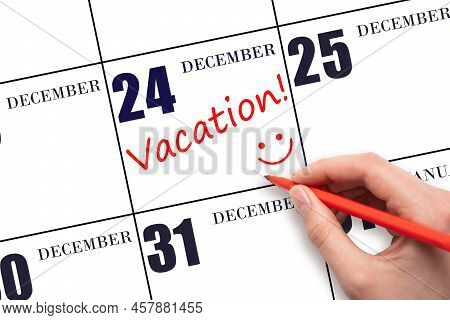 24th Day Of December. A Hand Writing A Vacation Text And Drawing A Smiling Face On A Calendar Date 2