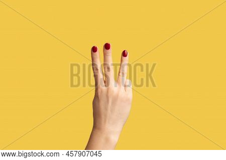 Profile Side View Closeup Of Woman Hand With Red Manicure Showing Number 3 Three With Hands. Indoor 