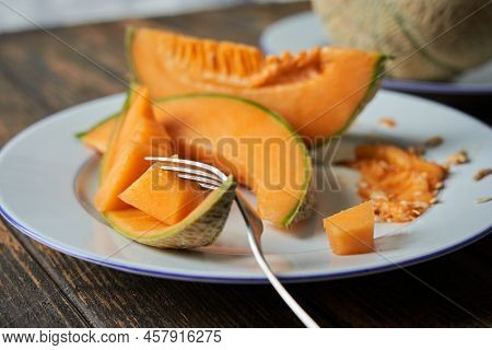 Slices Of Japanese Melons, Honey Melon Or Cantaloupe. Taking A Piece Of Melon With A Fork. Best Frui