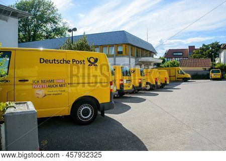 Oberkirch, Germany - May 27, 2022: Row Of Multiple Electric Volkswagen Yellow Vans With Deutsche Pos