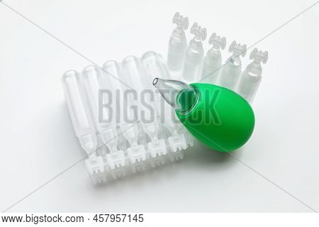 Single Dose Ampoules Of Sterile Isotonic Sea Water Solution And Nasal Aspirator On White Background