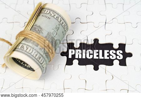 Business Concept. Dollars Lie On White Puzzles, On A Black Surface There Is An Inscription - Pricele