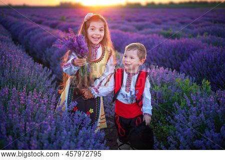 Portrait Of Children Boy And Girl In Traditional Bulgarian Folklore Costume In Lavender Field During