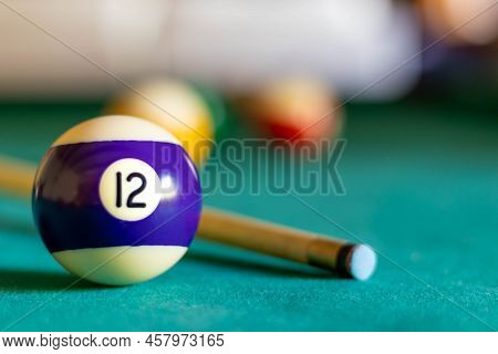 Billiard Twelve Ball On Green Tapestry And More Balls In The Backgrownd