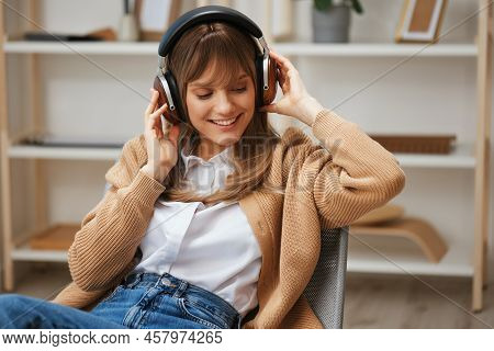 Cheerful Young Blonde Student Lady Freelancer In Warm Sweater In Headphones Enjoy Good Playlist List