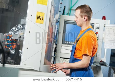 manufacture technician worker near cnc milling machine center at tool workshop