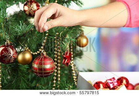 Decorating Christmas tree on bright background