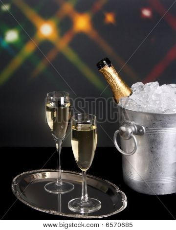 Champagne y cubo de hielo con luces de fondo
