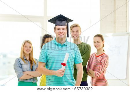 education and people concept - smiling male student with diploma and corner-cap and friends on the back