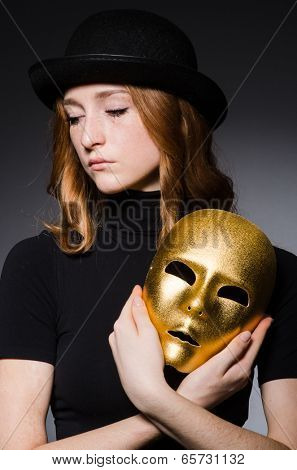 Redhead woman in hat  iwith mask in hypocrisy consept against dark  grey background