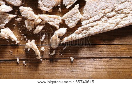 Crushed dietic rye bread on wooden background