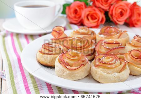 Tasty  puff pastry with apple shaped roses on plate on table close-up