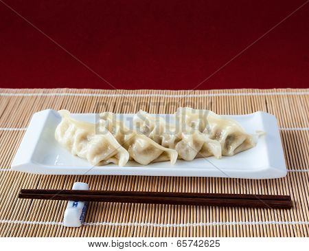 Gyoza Or Potstickers On Bamboo Mat With Copy Space
