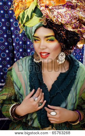 beauty bright woman with creative make up, many shawls on head like cubian woman