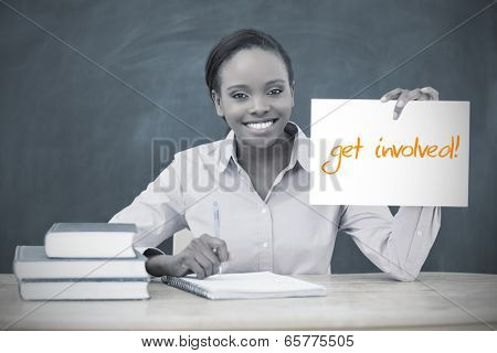 Happy teacher holding page showing get involved in her classroom at school