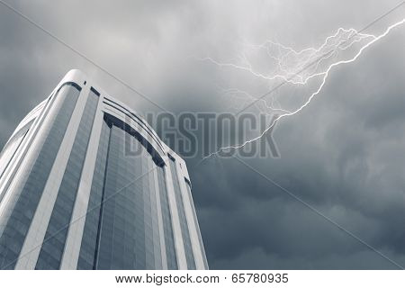 Bottom image of skyscraper with thunder lightning in sky