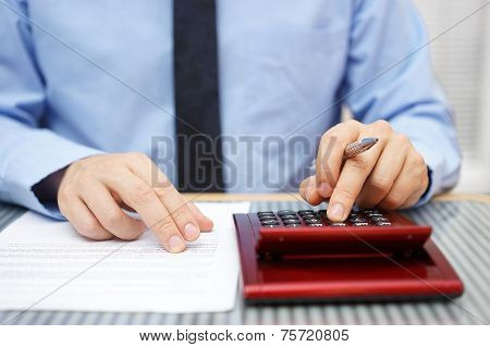 Businessman Calculating  And Checking Articles Of Agreement