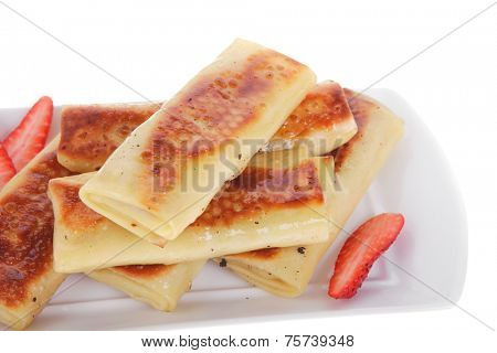 russian food - heap of sweet pancake filled with cottage cheese with strawberry served on white plate isolated over white high resolution hidef