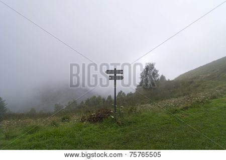 Pointer To A Hiking Trail In The Mountains Covered With Dense Fog.