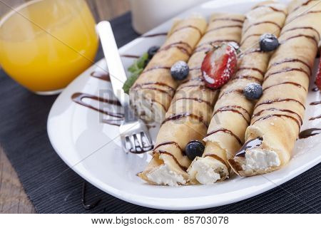 Delicious Sweet Rolled Pancakes On A Plate With Fresh Fruits