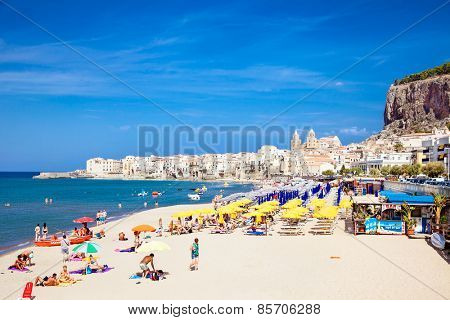 CEFALU,SICILY-SEP 16,2014: Unidentified people on sandy beach in Cefalu, Sicily, Italy at Sep 16, 2014. Cefalu is an attractive historic town and seaside resort.