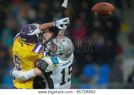 VIENNA, AUSTRIA - MARCH 23, 2014: DB Simon Unterrainer (#15 Raiders) and WR Laurinho Walch (#6 Vikings) fight for the ball in an AFL football game.