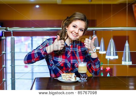 Girl In Plaid Shirt Shows Like To Cup Of Mokachino And Cake