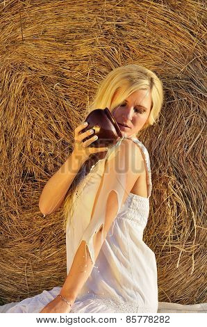 Happy woman drinking milk from cruse or crock