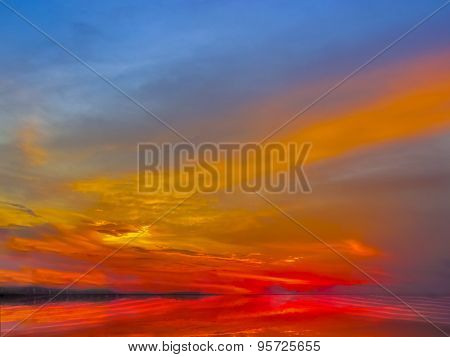 Sunset Sky Of Deep Multiple Colors Scaterred Rays Of Lights And Its Reflection On Water.