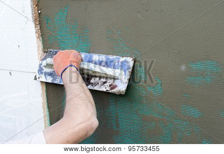 Applying Putty To The  Wall Using A Spatula