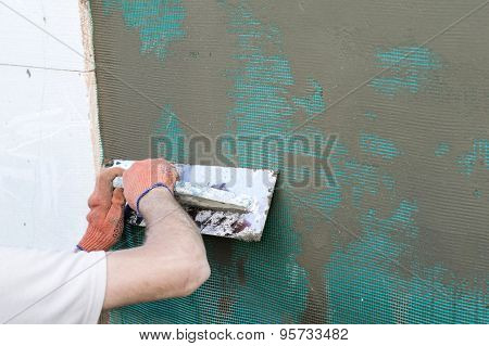 Applying Putty To The  Wall Using A Spatula