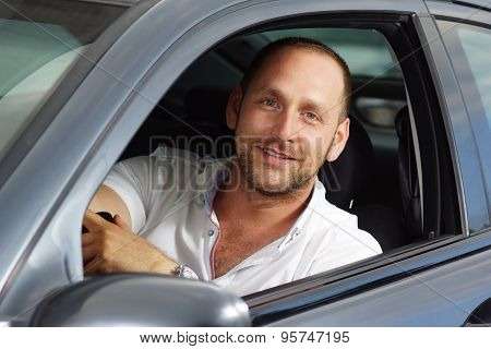 Middle age man smile into camera from driver seat
