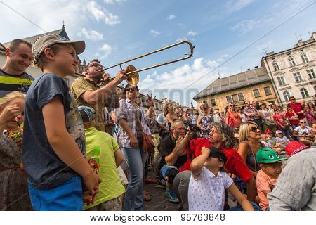 KRAKOW, POLAND - JUL 12, 2015: Participants at the annually (July 9-12) 28th International Festival of Street Theatres - Orchestre International du Vetex (Belgium/France) in the Main Square of Krakow.