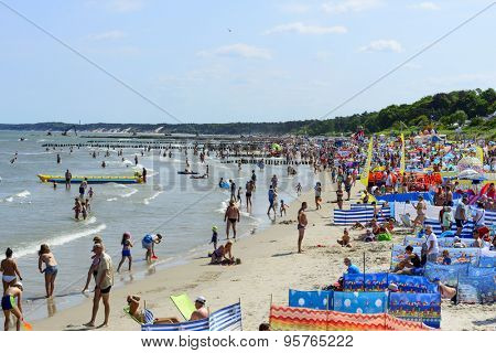 USTKA - JULY 07: Tourists enjoy the sunny weather and relaxing on the Baltic sea beach on 7 July 2015 in Ustka, Poland.