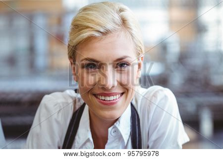 Selfassured female cook smiling in front of her bakery