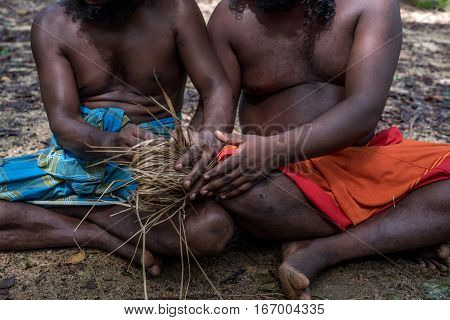 DABANA, SRI LANKA - CIRCA DECEMBER 2016: Vedda men making fire. Veddas are an indigenous people of Sri Lanka living in tribes in the jungle