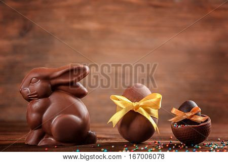 Chocolate Easter bunny with eggs on wooden background