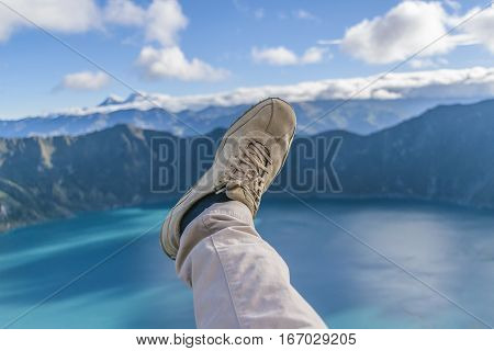 Funny photo showing a leg with trousers and shoes against quilotoa lake Latacunga Ecuador