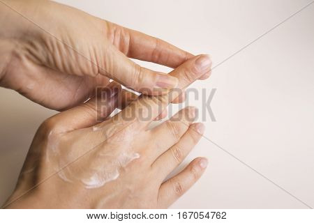 Hands of caucasian woman selfmassage with cream