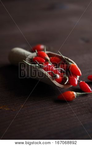 fresh healthy goji berries in front of a brown wooden background