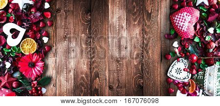 Valentine's Day Background with love themed elements like cotton and paper hearts, flowers, berries, oranges and other decorations. Wooden old parquet on the back.