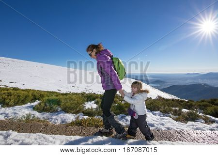 Mother And Child Hiking In Snow Mountain Summit