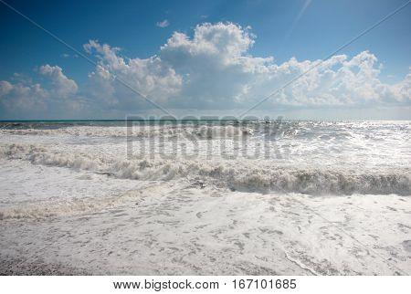 high waves and strong sea tide during a storm under sunny skies