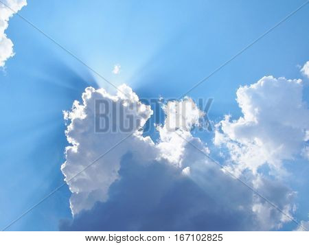 Beautiful sunburst on the blue sky with clouds