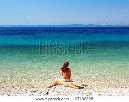 Woman sitting on the beautiful beach in Croatia