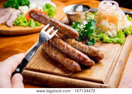 fried sausage with sauerkraut and mustard sauce on a wooden board