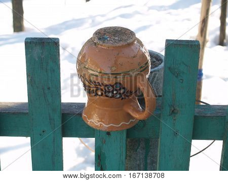 ceramic glechik upside-down weighs on the fence